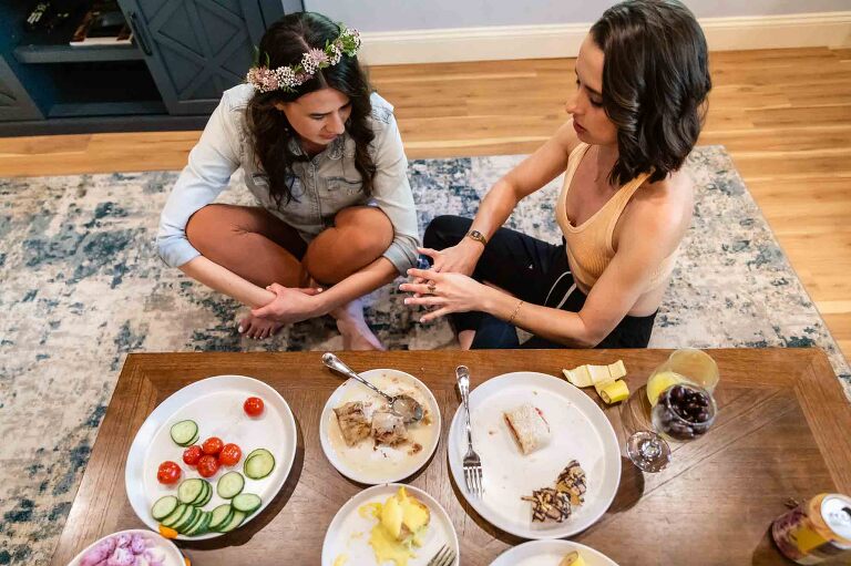 bride and her sister talk about wedding rings as they relax before getting ready for the wedding. these kinds of moments are treasured by couples looking for a photojournalist who photographs weddings