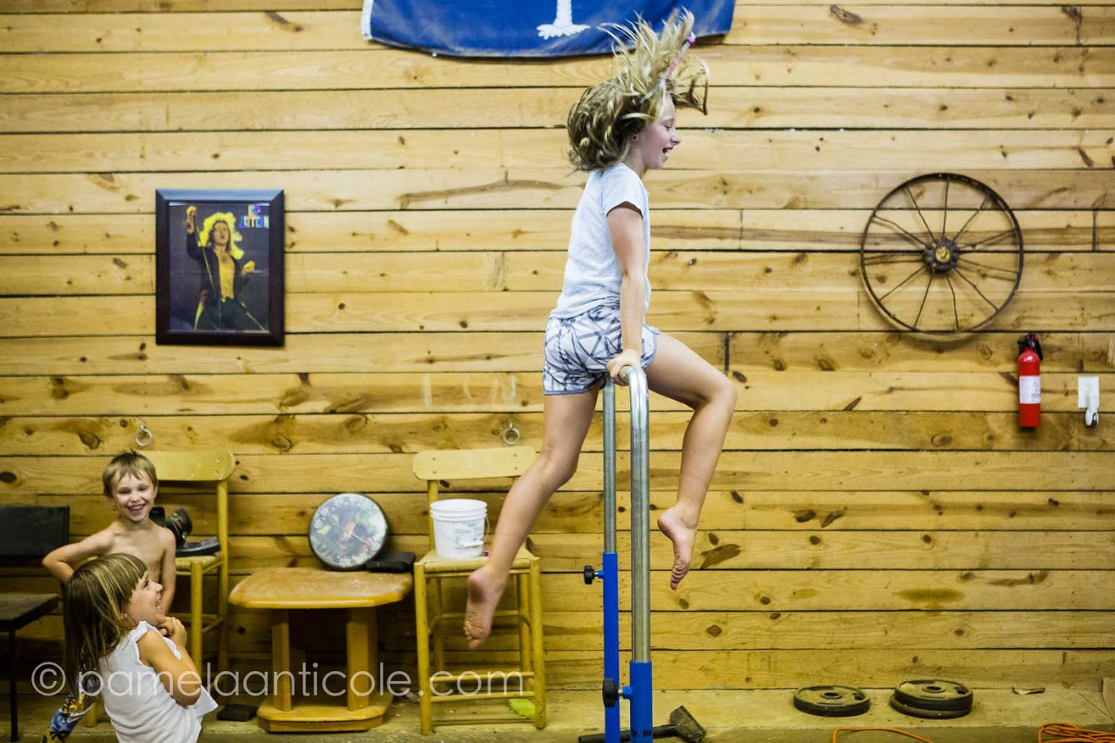 family photographer in south carolina kids playing gymnastics on a beam in the farm