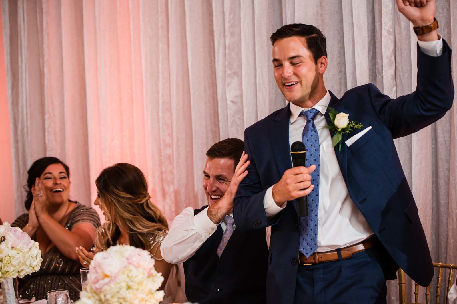 best man speech with lots of laughs, groom hides his face in his hands. 