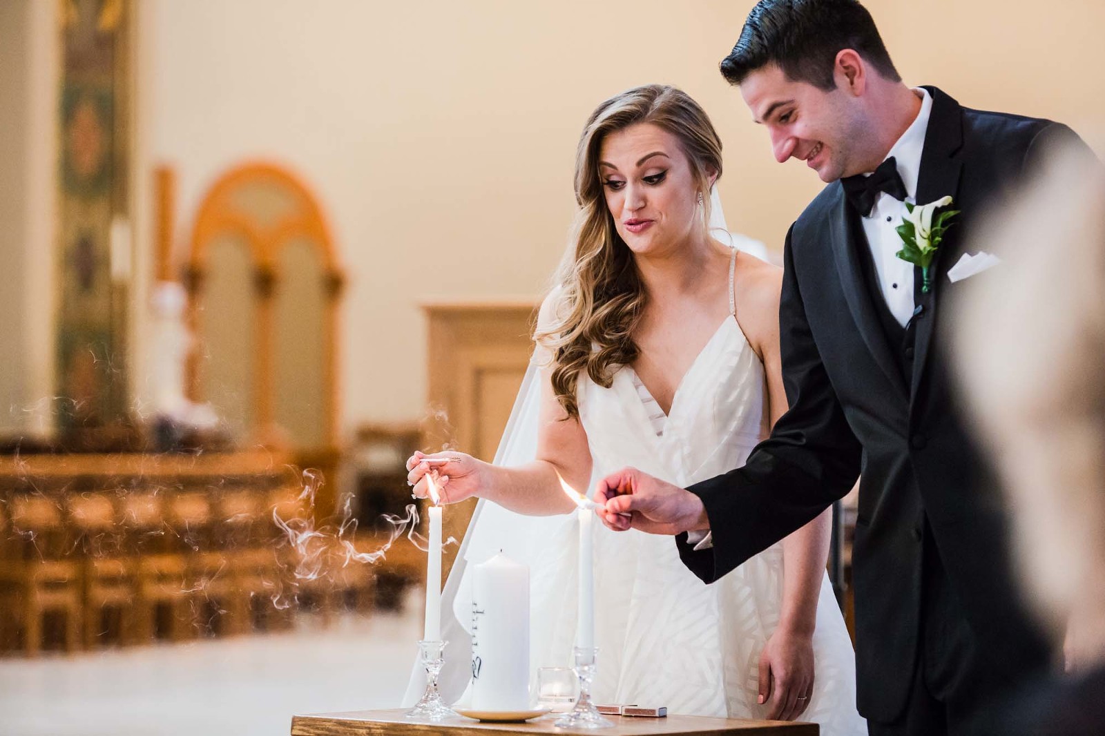 bride and groom at st. vincent basilica church wedding ceremony, lighting unity candle and making funny faces