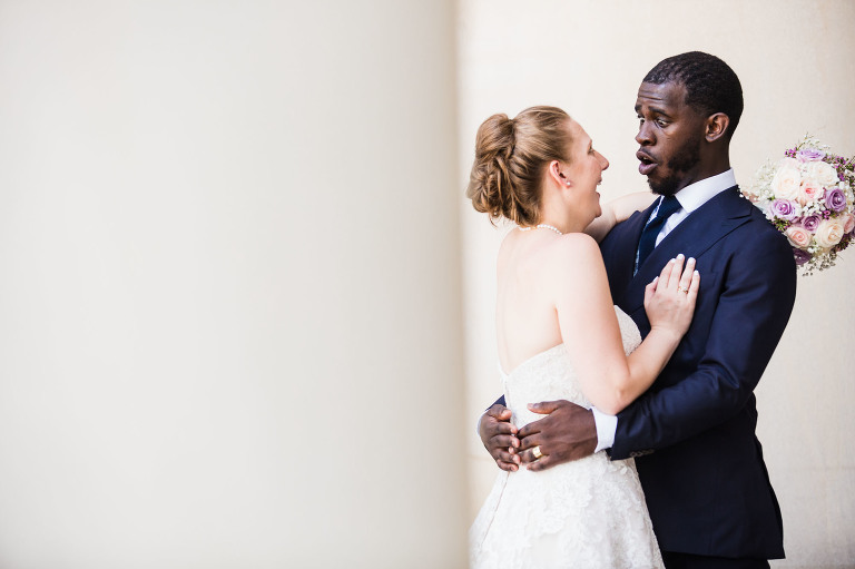 hilarious moment between a young bride and her emotional groom during their photoshoot at the architectural columns at the mellon building in oakland, pittsburgh pa