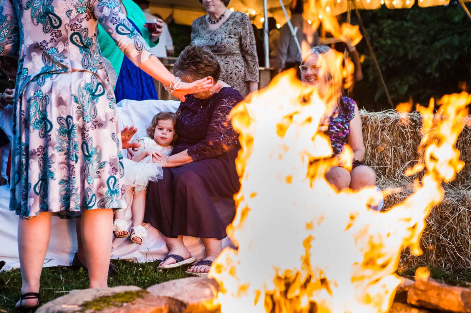 wedding guests snuggle around the late night bonfire at the reception