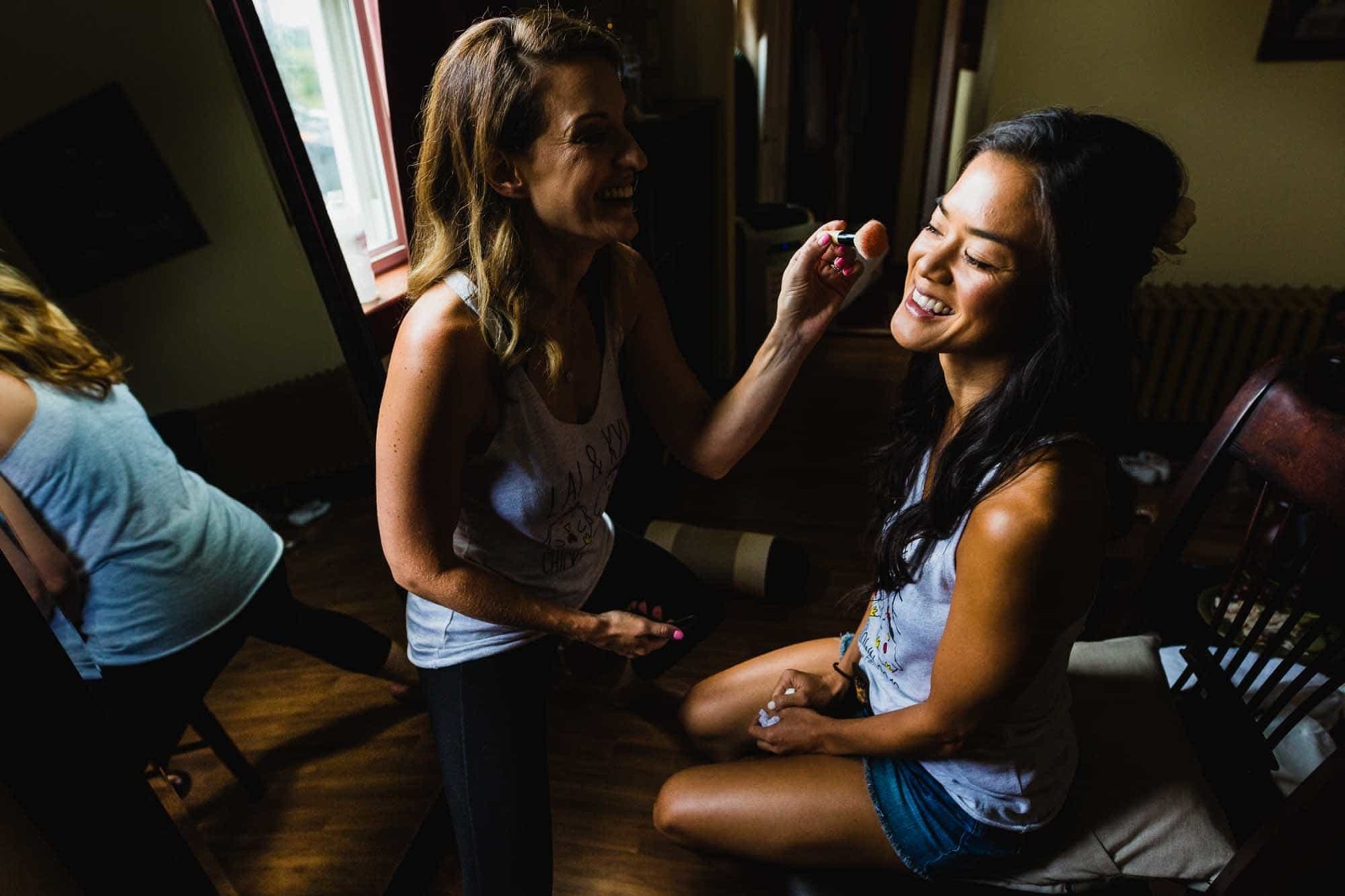 asian bride getting makeup applied by her friend