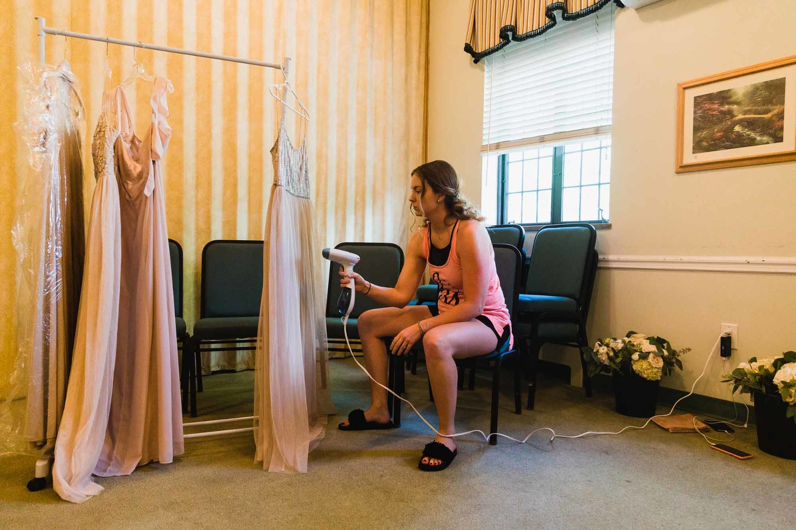 bridesmaid prepares the bridesmaid dresses with steam cleaner, before wedding ceremony, in church basement at beverly heights presbyterian in mount lebanon, pa