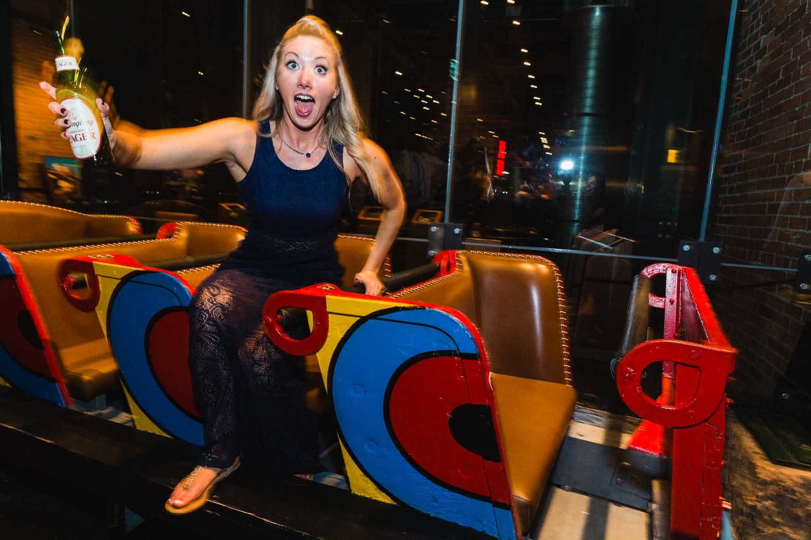 bridesmaid having fun at heinz history center wedding reception, laughing and goofing off in the kennywood racer car for a photograph