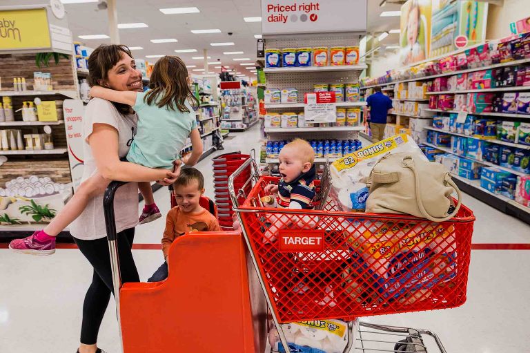mom takes three young kids through target, riding on the cart