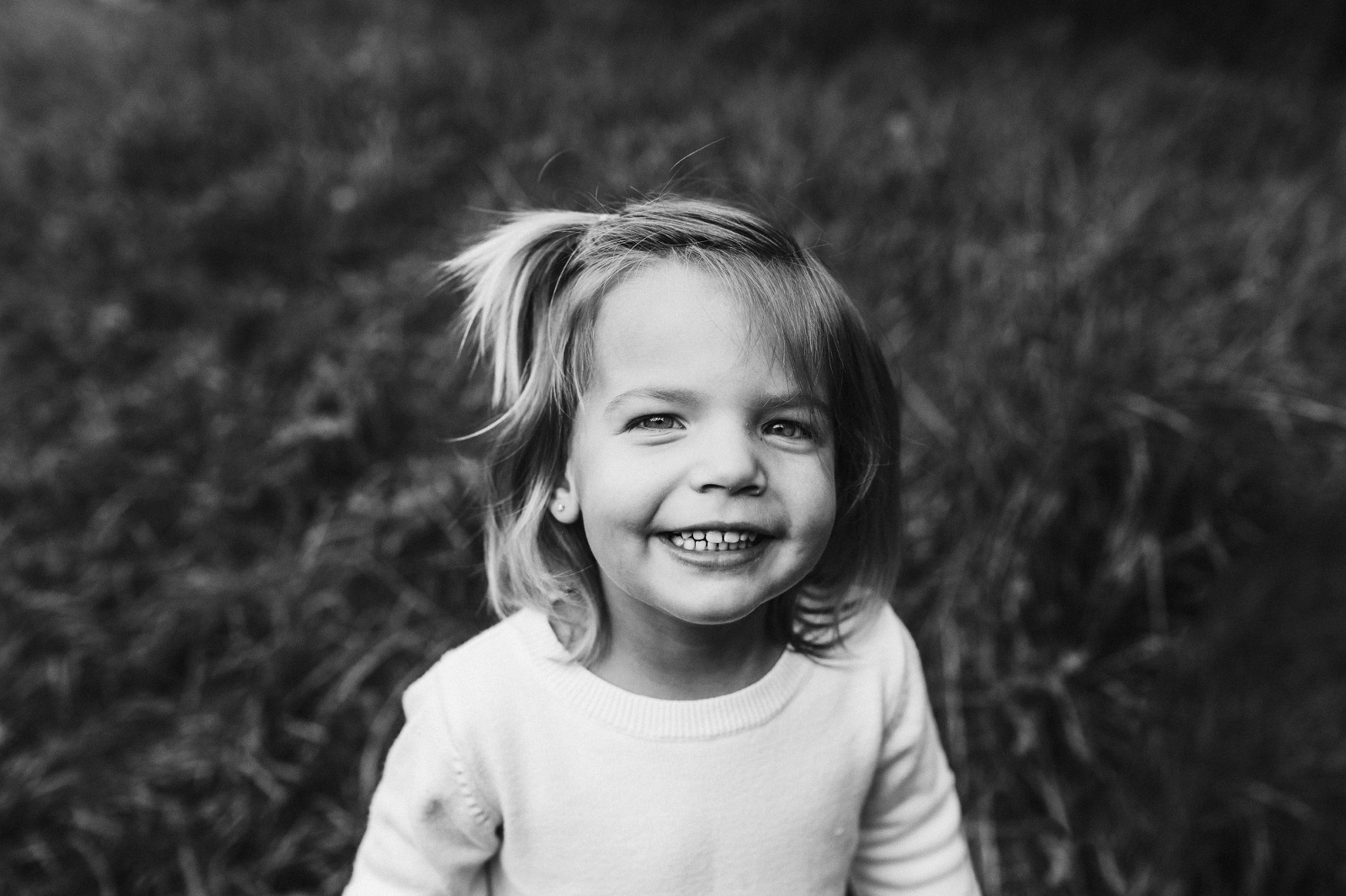 black and white candid portrait of little girl photographed with wide lens