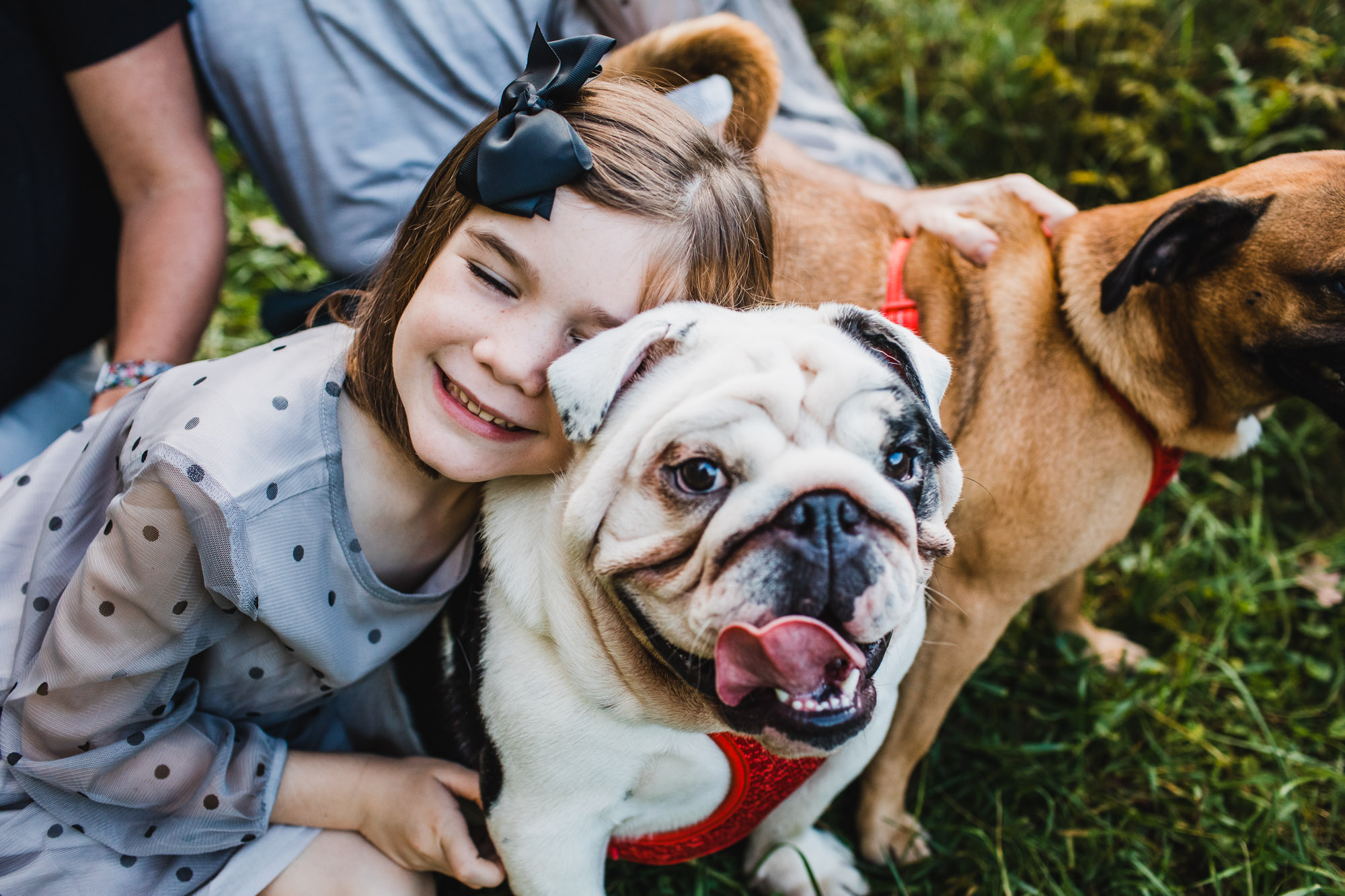little girl with her puppy smiling and hugging