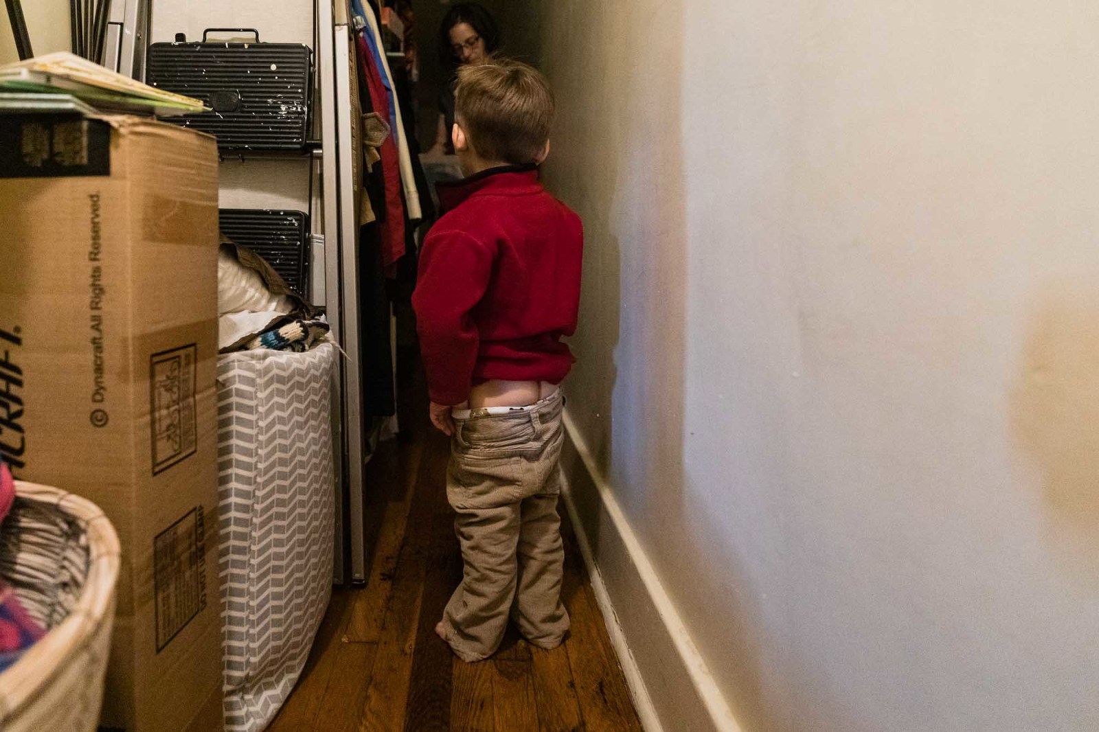 toddler pulls his pants down to display his bum, nonchalantly while talking to his mom