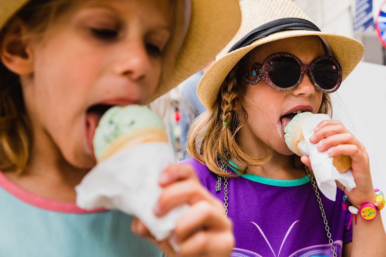 twin girls eating ice cream on a hot summer day