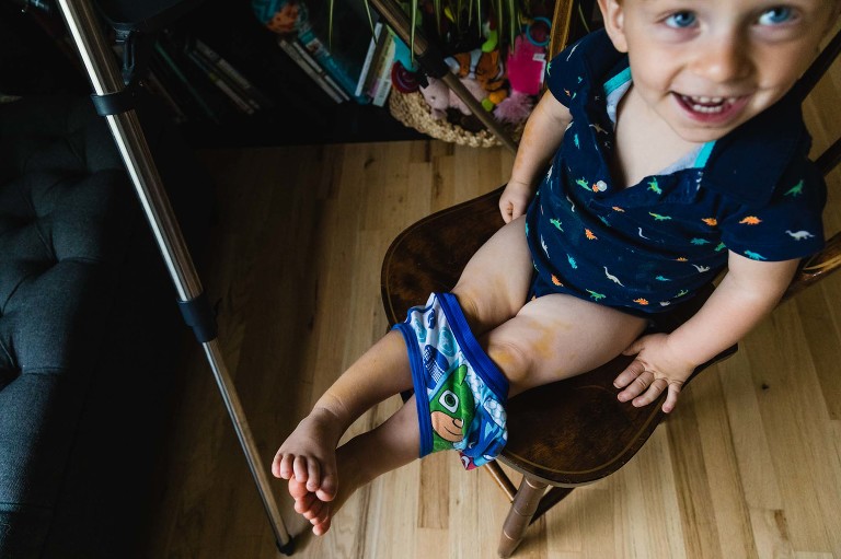 toddler trying on underwear and laughing proudly.