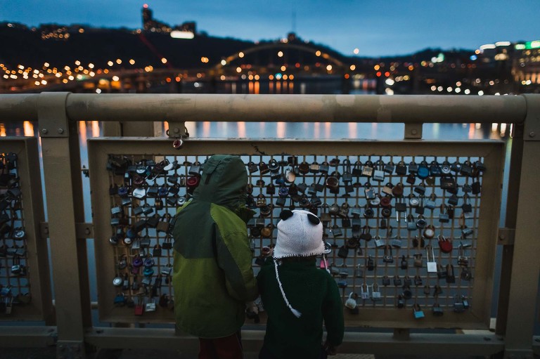 kids look at the love locks on the roberto clemente bridge, at night, over the allegheny river in pittsburgh