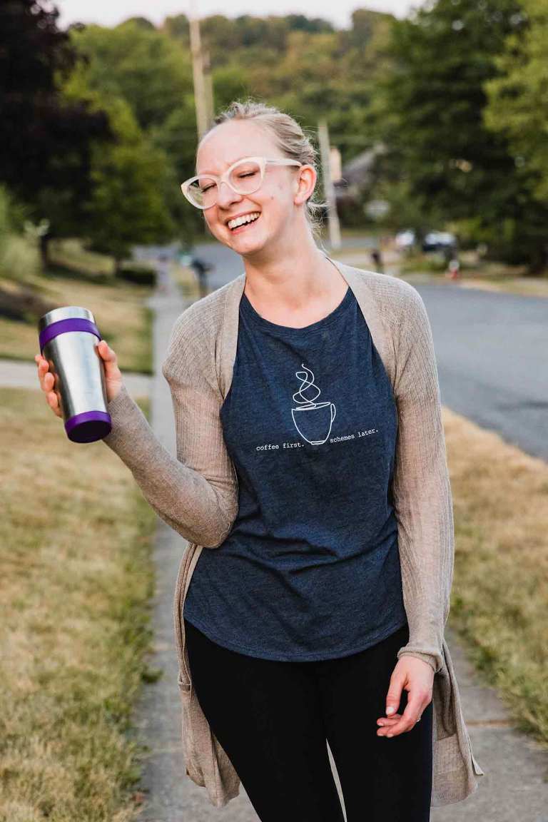 stylish mom in leggings holding coffee and wearing a fun shirt