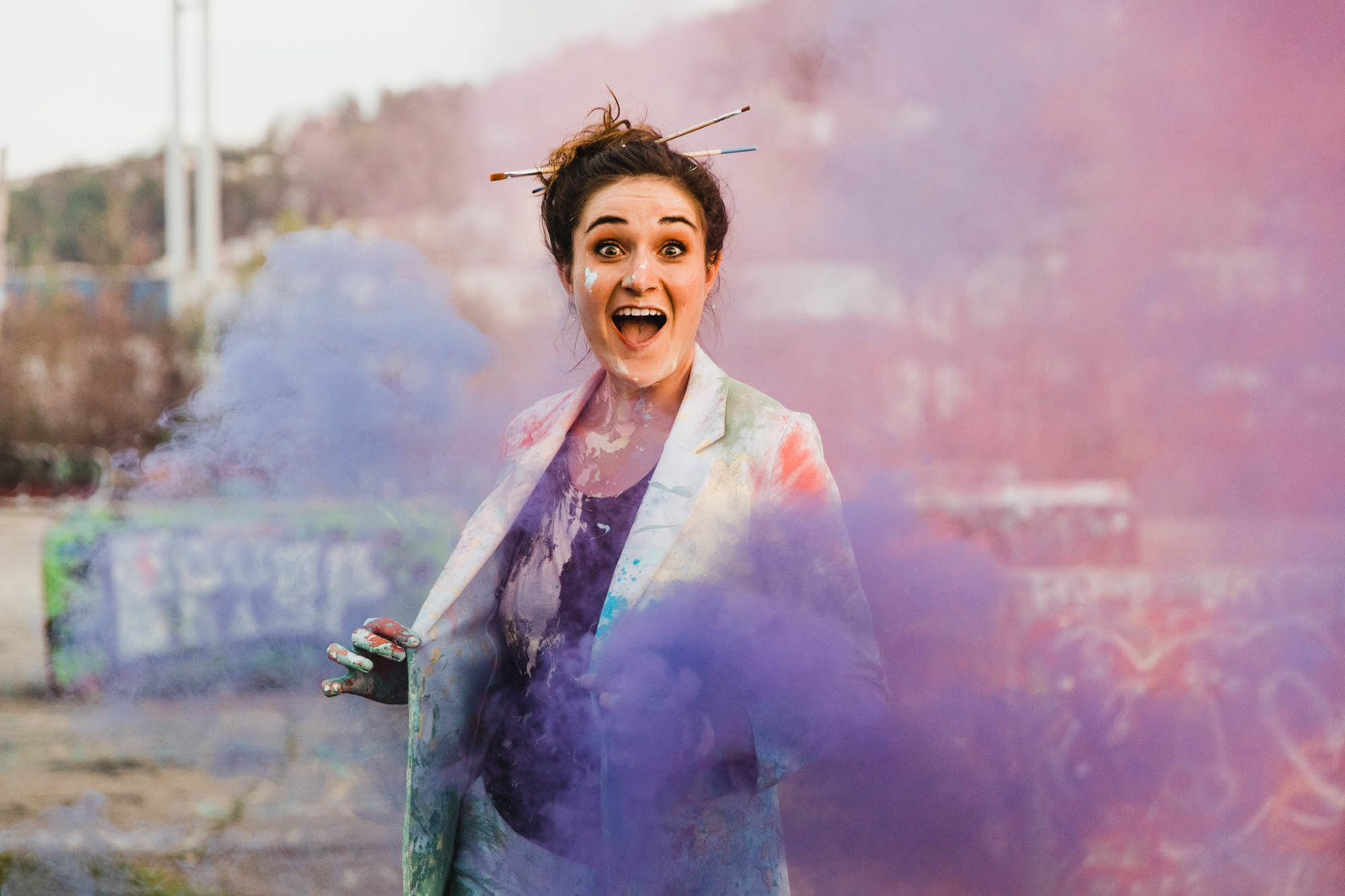 artist is covered and paint surrounded by colorful smoke bombs