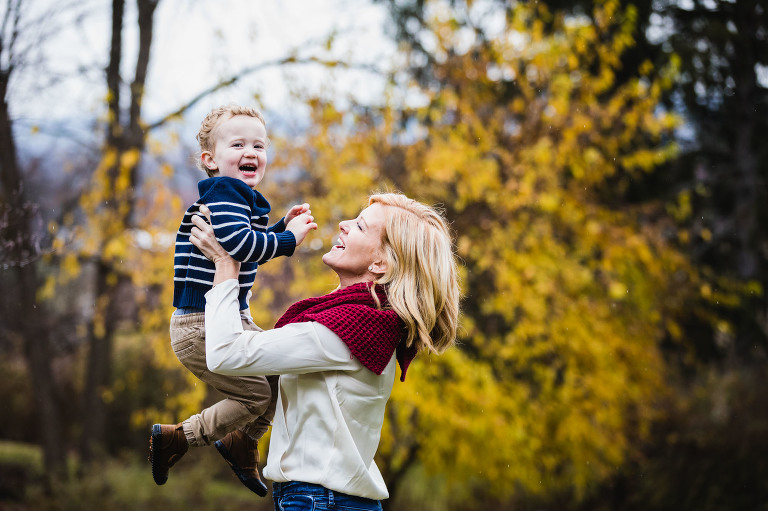 mom throws her son up into the air laughing
