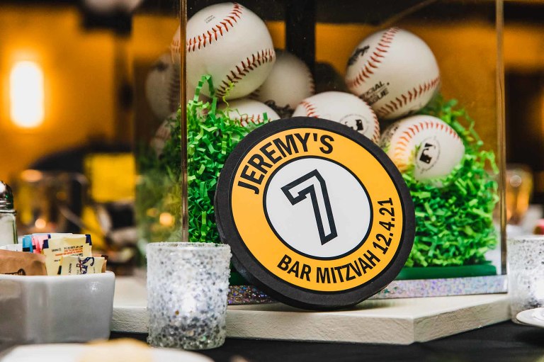 table centerpiece for a bar mitzvah, filled with baseballs and themed with black and white pittsburgh sports teams
