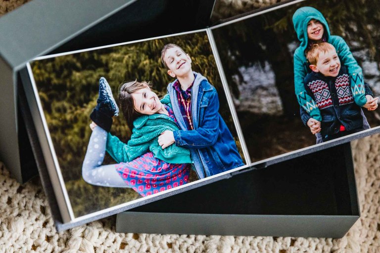 photo of open photo album with one page per side, on hard pages with linen cover, cradled by picture box