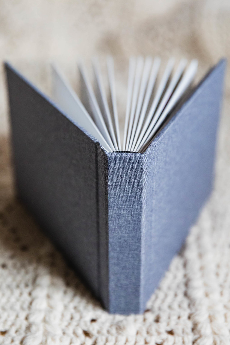 picture of hard flush mount album bound in linen cover, photographed from above while strewn open