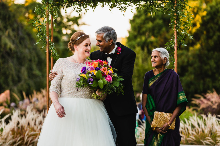 bride and groom standing in front of arch when they elope in one of Pittsburgh small wedding venues phipps conservatory outdoor garden