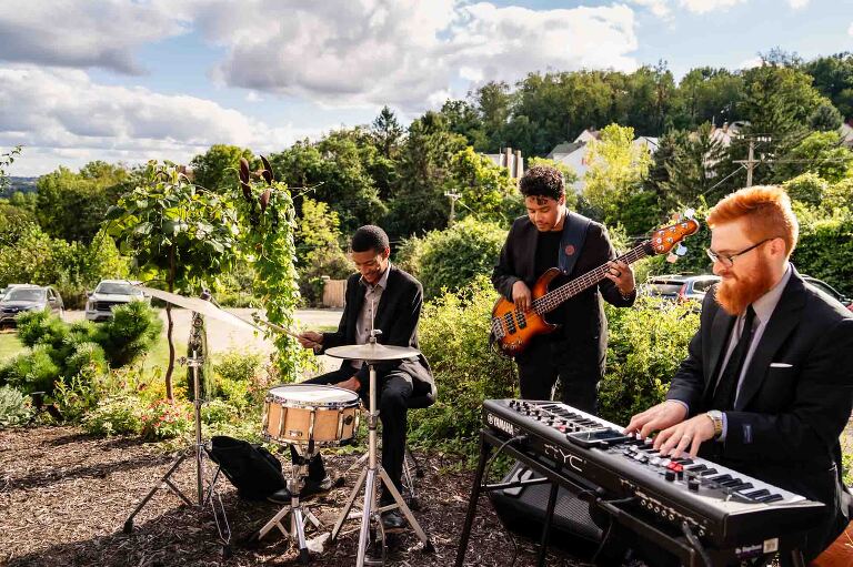 musicians play on a lawn during cocktail hour, as part of WBU Event Venue wedding photos provided to this bride and groom