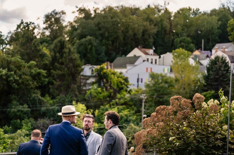 wedding guests have a conversation with city homes in the background, in WBU Event Venue wedding photos