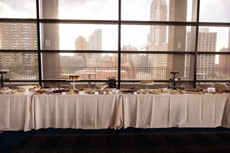 photo of cookie table at pittsburgh wedding, in front of wall of windows at duquesne power center ballroom wedding, with the pittsburgh skyline in the background.