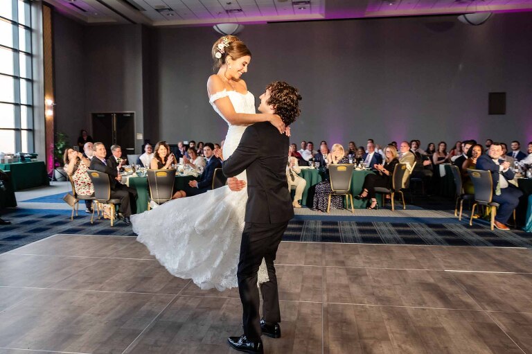 groom lifts bride up on the dance floor in the dougherty ballroom at the power center on duquesne university's campus