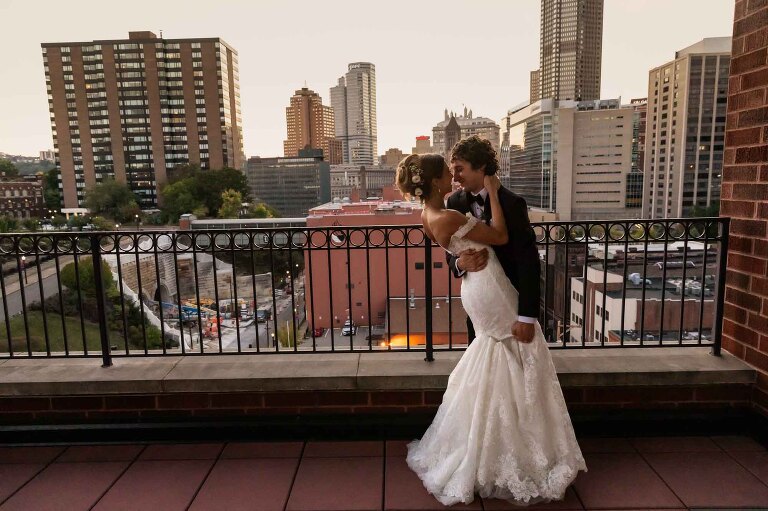 wedding photos in pittsburgh duquesne power center ballroom, on the balcony with the city in the background behind the bride and groom.