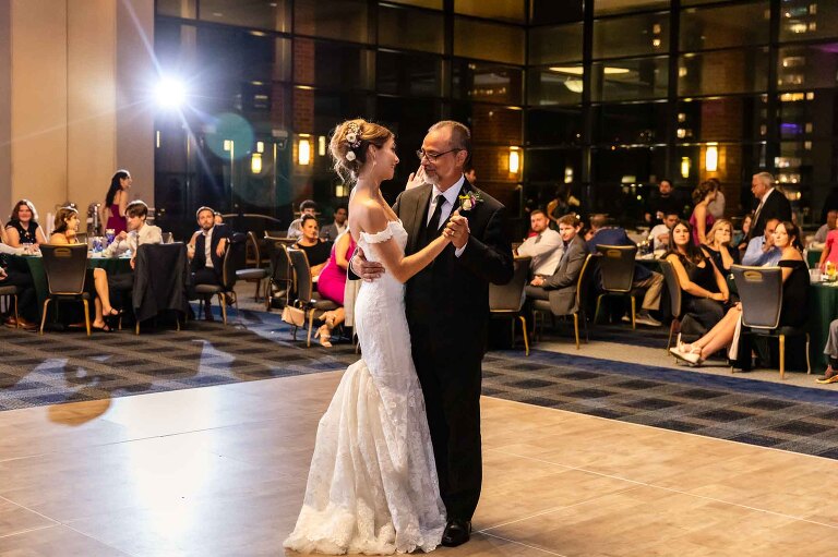 duquesne power center wedding photos of the dance floor with pittsburgh city in the background behind wall of windows