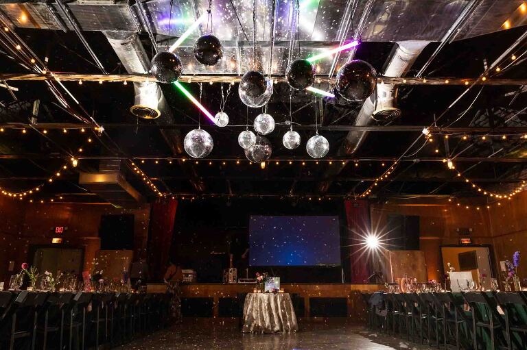 small sweetheart table sits in front of a stage at spirit pittsburgh, one of the most unique wedding venues in pittsburgh pa (and historical, too!)
