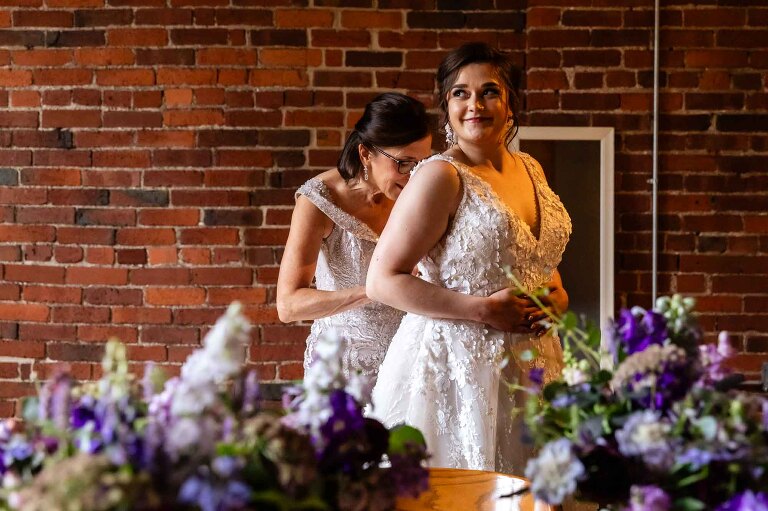 bride gets ready with her mom for her heinz history center wedding, in the separate bridal spaces on site at this unique pittsburgh wedding venue