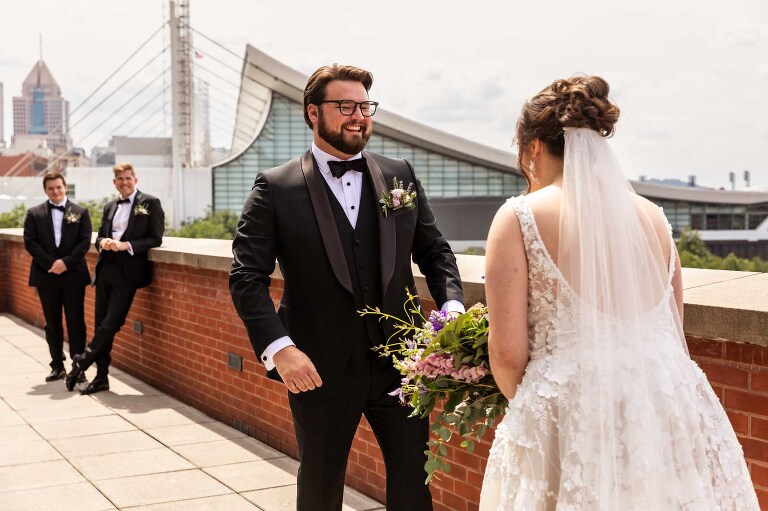 first look on the balcony at the heinz history center wedding venue, outside the mueller center. candid pictures taken by pittsburgh wedding photographer pamela anticole
