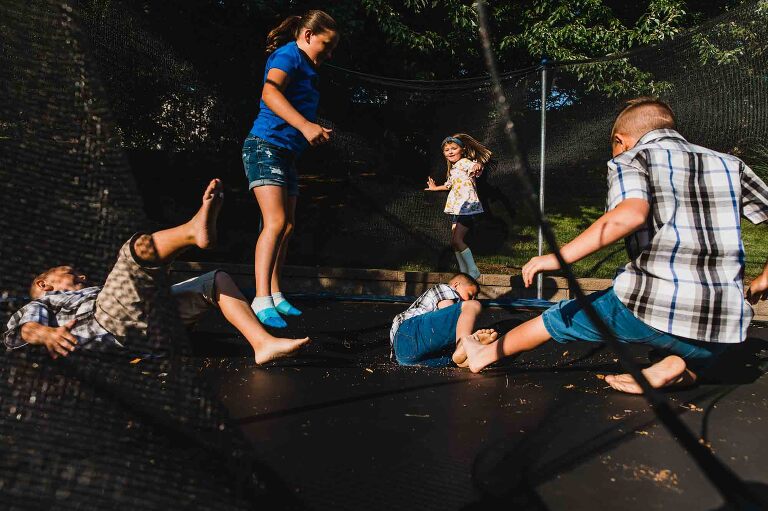 kids playing on a trampoline in the backyard