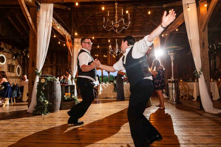 groomsmen and groom dance together wildly at the wedding reception at pinehall at eisler farm